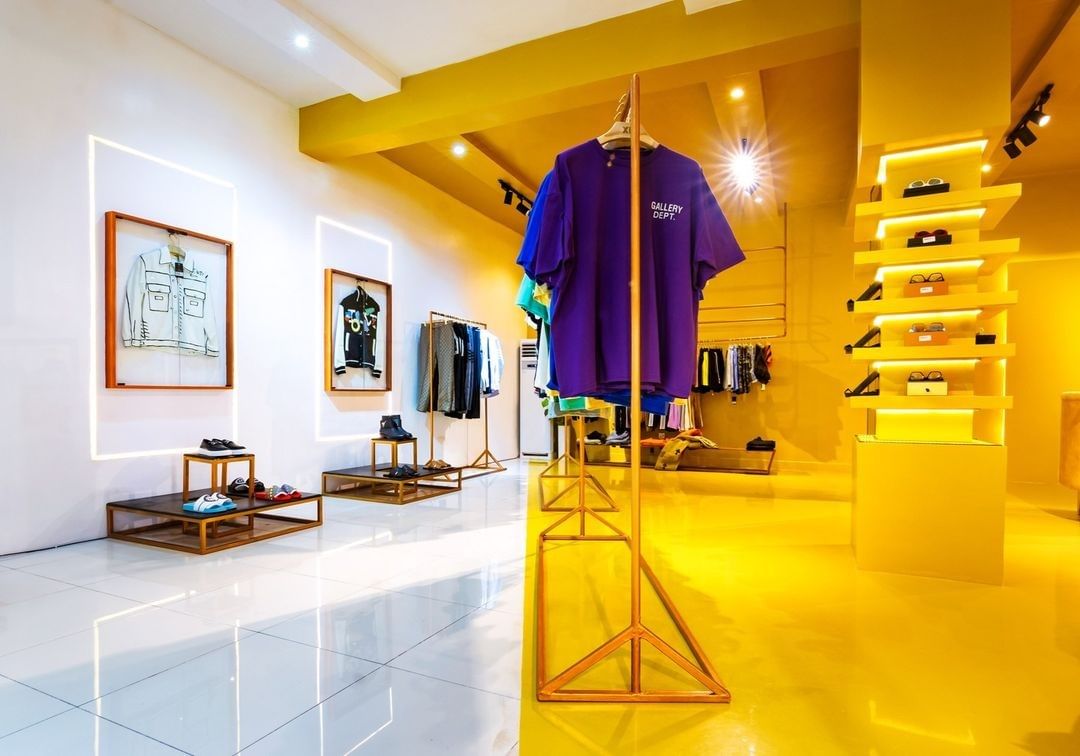 white space transitioning to the gold/yellow room of room xix - a modern fashion store by dhk designs.